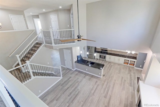 2901 Madison Ln, Broomfield, CO 80023 - stairway featuring wood finished floors, recessed lighting, a ceiling fan, a towering ceiling, and a chandelier