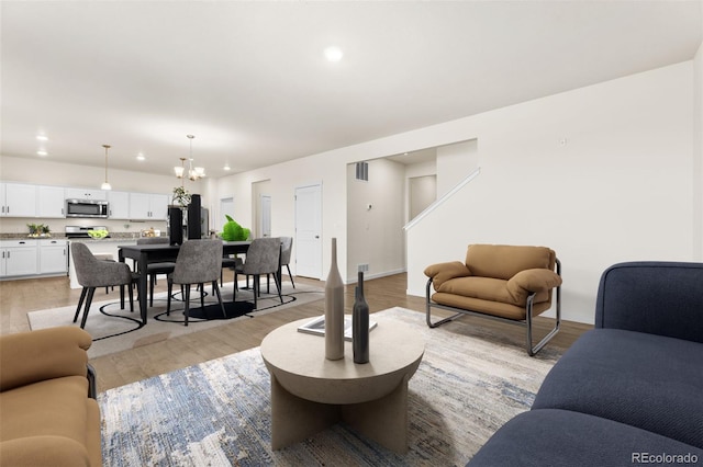 living room featuring light hardwood / wood-style floors and an inviting chandelier