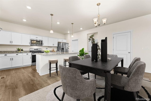 dining space featuring a notable chandelier and hardwood / wood-style flooring