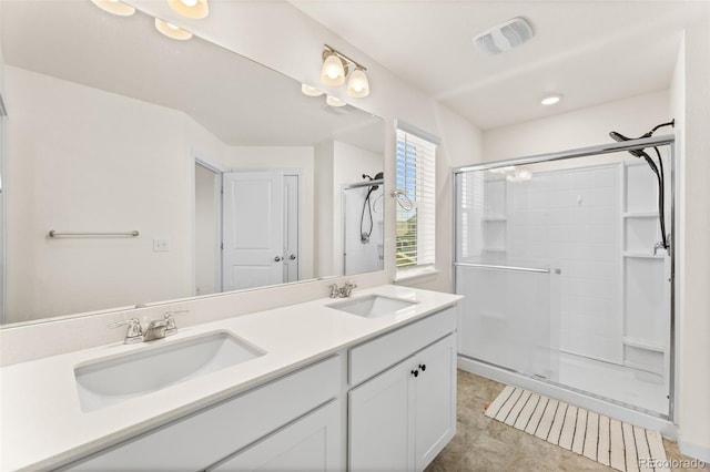 bathroom with vanity, a shower with shower door, and tile patterned floors