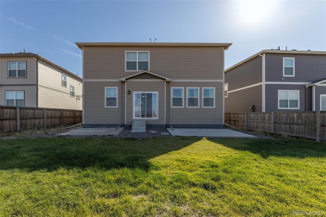 back of property with a yard and a patio area