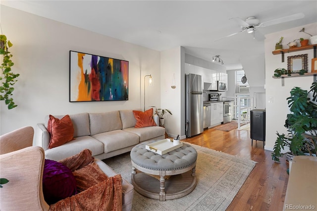 living room featuring ceiling fan and light hardwood / wood-style flooring