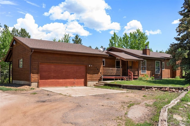 1908 Valley View Dr, Woodland Park, CO 80863 - chalet / cabin with driveway, a chimney, a garage, covered porch, and a front yard