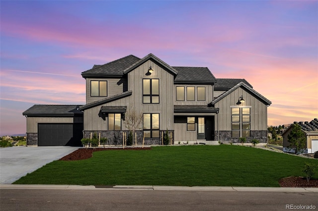 modern inspired farmhouse with a lawn and a garage