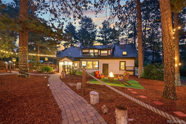 233 Perry Park Ave, Larkspur, CO 80118 - rear view of property featuring a fire pit, a metal roof, a standing seam roof, and a chimney