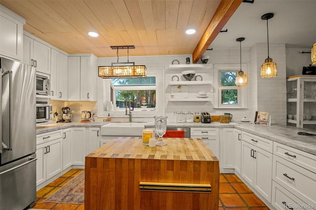 233 Perry Park Ave, Larkspur, CO 80118 - kitchen with stainless steel appliances, butcher block countertops, healthy amount of natural light, backsplash, and a wooden ceiling with exposed beams