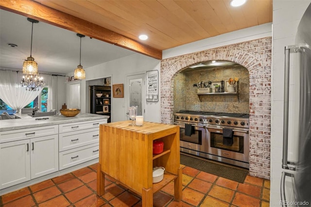 233 Perry Park Ave, Larkspur, CO 80118 - kitchen with double oven range, wood counters, white cabinets, fridge, and pendant lighting