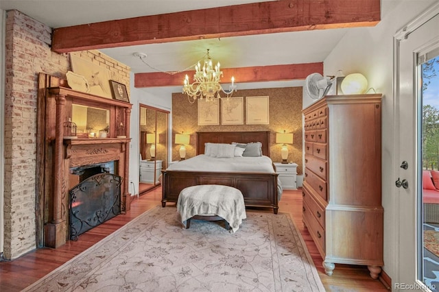 233 Perry Park Ave, Larkspur, CO 80118 - bedroom featuring light wood-style flooring, beam ceiling, a fireplace, and a chandelier
