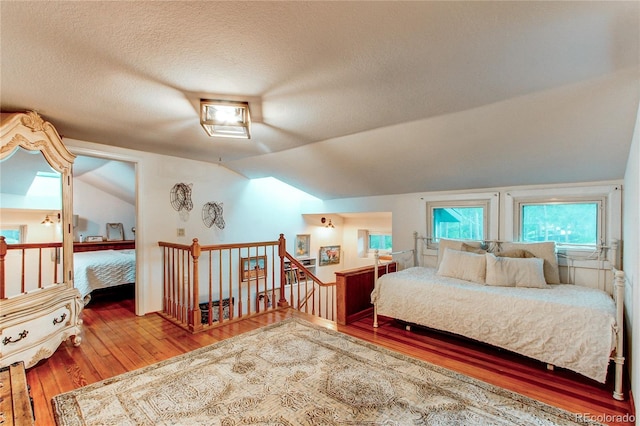 233 Perry Park Ave, Larkspur, CO 80118 - bedroom with hardwood / wood-style flooring, lofted ceiling, and a textured ceiling