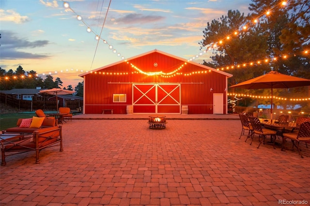 233 Perry Park Ave, Larkspur, CO 80118 - patio terrace at dusk with an outbuilding, a patio area, and a barn