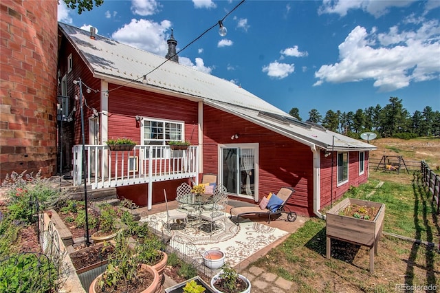 233 Perry Park Ave, Larkspur, CO 80118 - rear view of house featuring a vegetable garden, a patio, and a metal roof