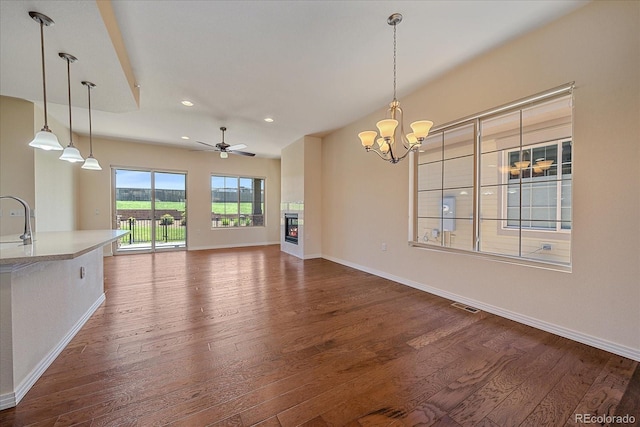 1130 Summit View Dr, Louisville, CO 80027 - unfurnished living room featuring dark wood-type flooring, baseboards, a chandelier, a glass covered fireplace, and recessed lighting