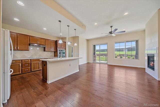 1130 Summit View Dr, Louisville, CO 80027 - kitchen featuring freestanding refrigerator, brown cabinetry, open floor plan, backsplash, and light countertops