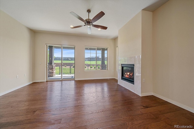 1130 Summit View Dr, Louisville, CO 80027 - unfurnished living room featuring dark wood-type flooring, a tiled fireplace, baseboards, and ceiling fan