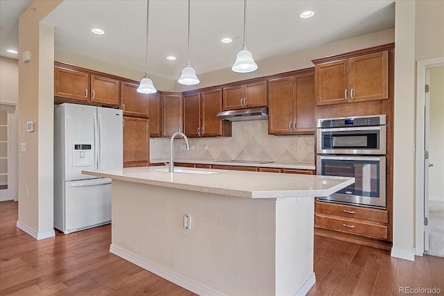 1130 Summit View Dr, Louisville, CO 80027 - kitchen featuring white refrigerator with ice dispenser, under cabinet range hood, a sink, stainless steel double oven, and dark wood finished floors