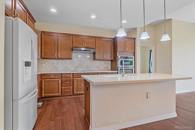1130 Summit View Dr, Louisville, CO 80027 - kitchen with white refrigerator with ice dispenser, under cabinet range hood, dark wood-type flooring, double oven, and light countertops