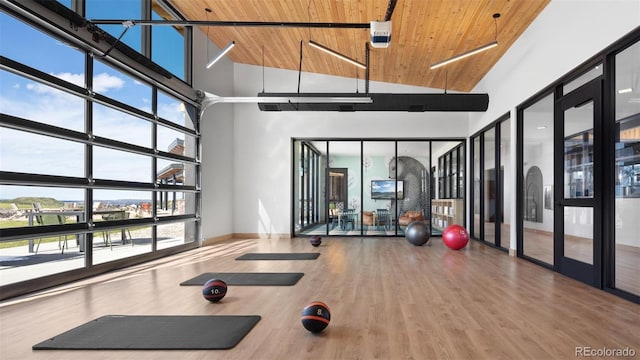 workout room with wood finished floors, baseboards, high vaulted ceiling, wooden ceiling, and french doors