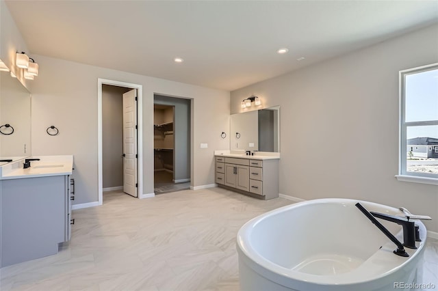 4748 Weitbrec Ln, Castle Rock, CO 80104 - full bathroom featuring two vanities, a freestanding tub, a walk in closet, baseboards, and recessed lighting