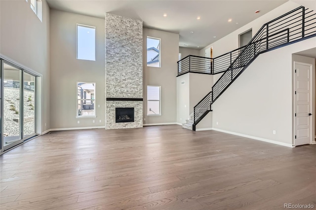 4748 Weitbrec Ln, Castle Rock, CO 80104 - unfurnished living room with a towering ceiling, plenty of natural light, stairway, wood finished floors, and recessed lighting