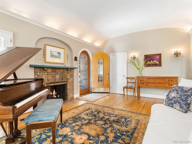 interior space featuring a fireplace, vaulted ceiling, and hardwood / wood-style floors