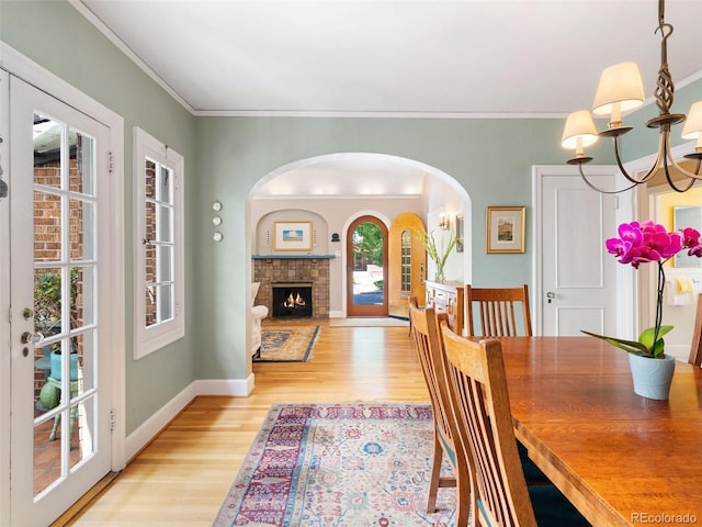 dining room with crown molding, light hardwood / wood-style flooring, and a notable chandelier