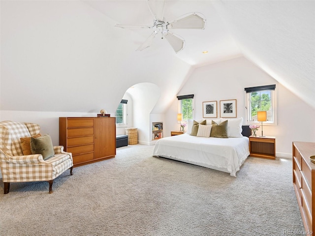 bedroom featuring light carpet, vaulted ceiling, multiple windows, and ceiling fan