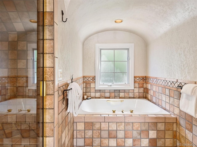 bathroom with independent shower and bath and lofted ceiling