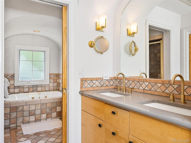 bathroom featuring vanity and a relaxing tiled tub