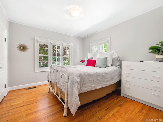 bedroom with ornamental molding and hardwood / wood-style flooring