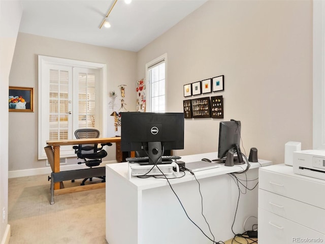 office space with track lighting and light colored carpet