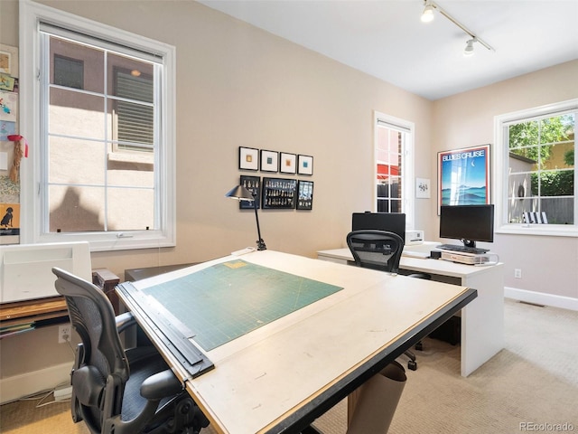 carpeted home office featuring track lighting