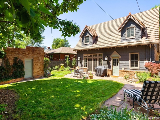 rear view of property featuring a yard and a patio