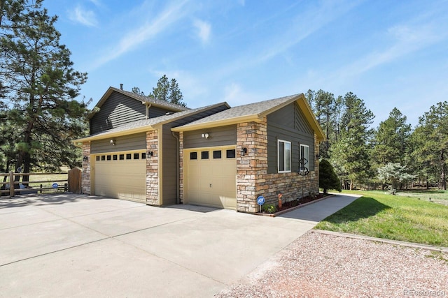 view of side of property featuring concrete driveway, stone siding, and a garage