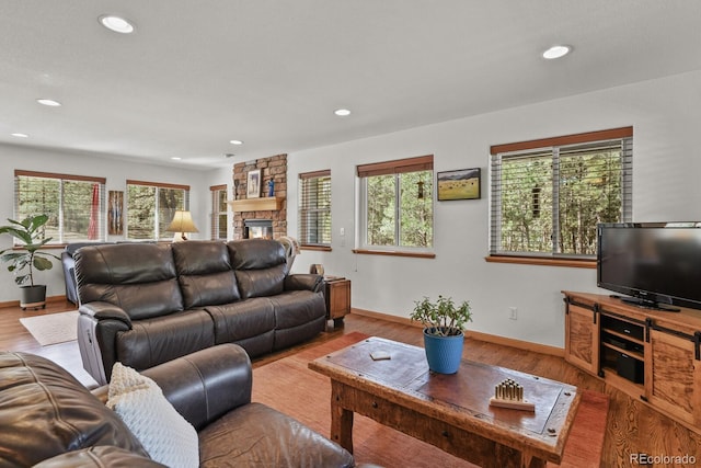 living area featuring wood finished floors, a fireplace, recessed lighting, and baseboards