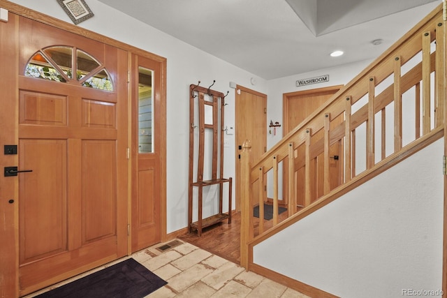 entryway with recessed lighting, baseboards, light stone finish flooring, and stairway