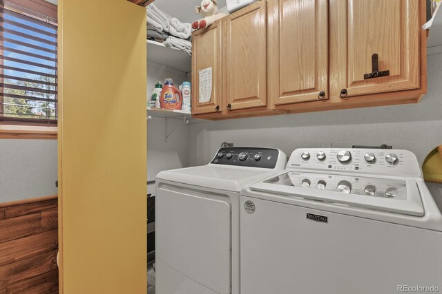 clothes washing area featuring washer and clothes dryer and cabinet space