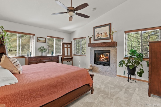 bedroom with light carpet, lofted ceiling, and a fireplace