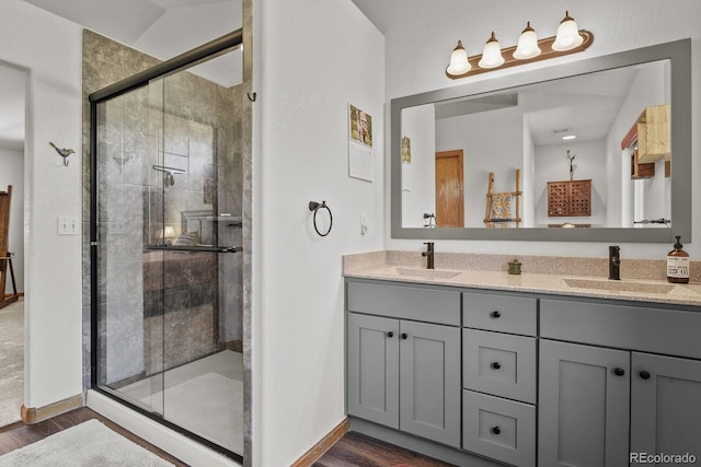 bathroom with wood finished floors, a shower stall, and baseboards