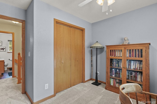 sitting room with carpet flooring, a ceiling fan, and baseboards