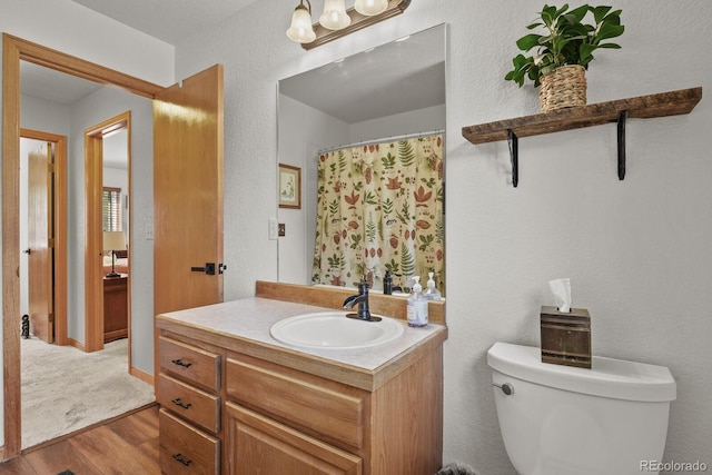 full bathroom with wood finished floors, toilet, vanity, a chandelier, and a shower with curtain