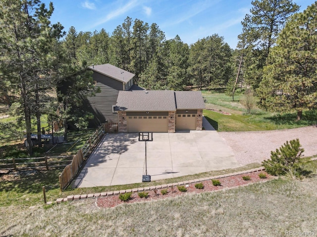 view of front of house with an attached garage, concrete driveway, and stone siding