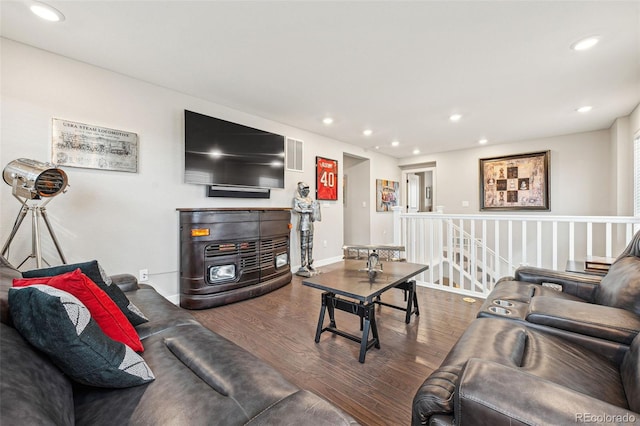 living area with baseboards, wood finished floors, visible vents, and recessed lighting