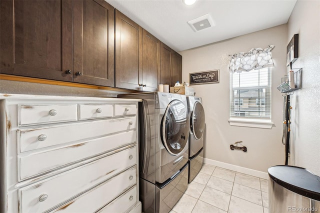 laundry area with cabinet space, light tile patterned floors, baseboards, and separate washer and dryer