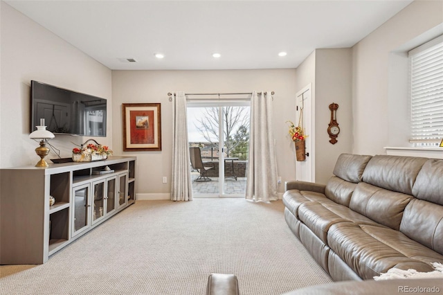 carpeted living room featuring baseboards, visible vents, and recessed lighting