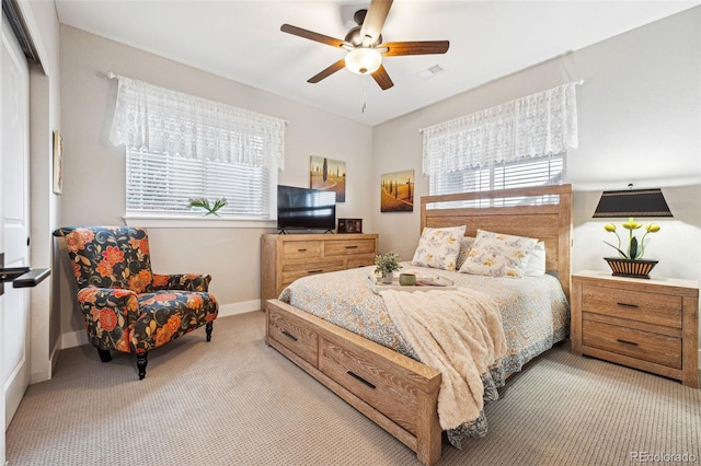 bedroom featuring light carpet, multiple windows, visible vents, and baseboards