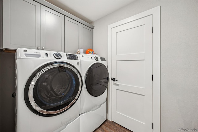 laundry area featuring dark wood finished floors, washing machine and dryer, and cabinet space