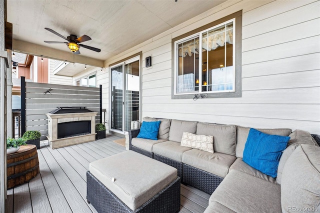 wooden deck featuring outdoor lounge area and a ceiling fan