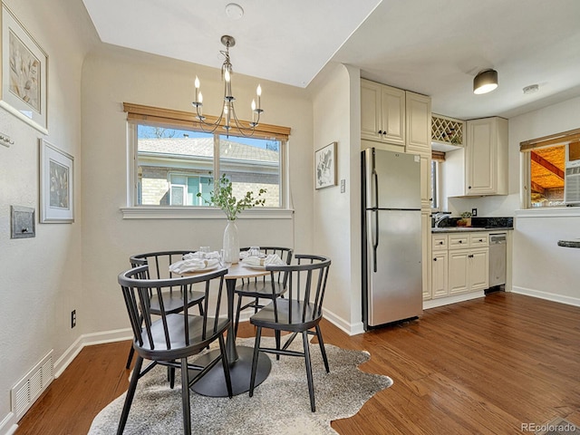 732 Poplar St, Denver, CO 80220 - dining room with a chandelier, dark wood-style floors, and baseboards