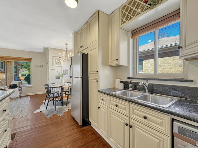 732 Poplar St, Denver, CO 80220 - kitchen with appliances with stainless steel finishes, cream cabinetry, dark countertops, dark wood finished floors, and a sink