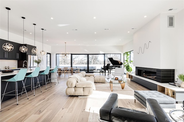 living room with a chandelier and light hardwood / wood-style flooring